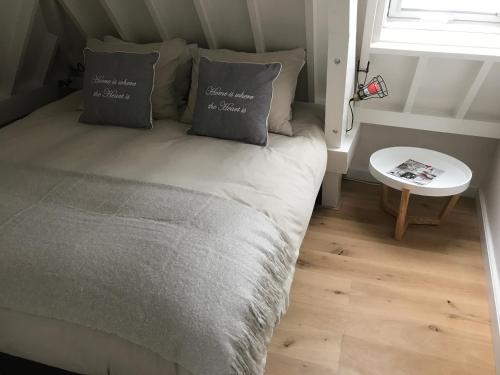 a bedroom with a bed with two pillows and a window at Mooi Genieten in Middelburg