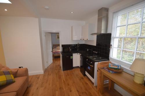 a kitchen with black appliances and a couch in a room at Little Weech in Dawlish