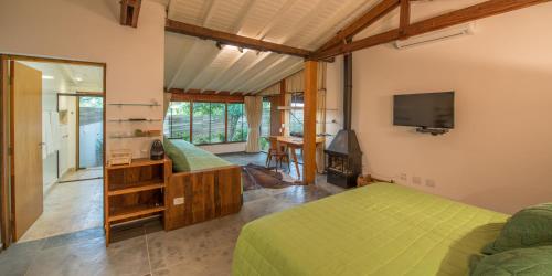 a bedroom with a green bed and a television at Fazenda Capoava in Itu