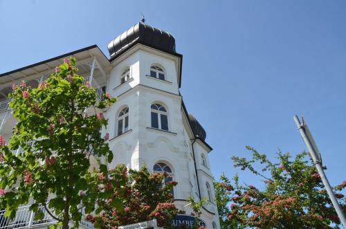 a tall white building with a clock tower at Haus Metropol - Fewo 7 mit Balkon und Meerblick in Binz