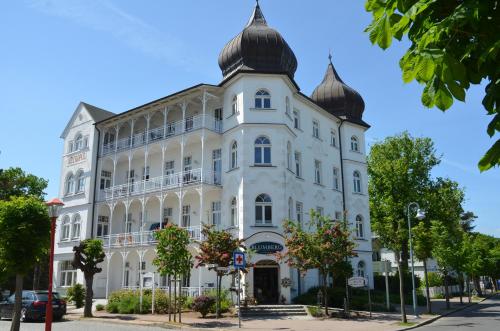 a large white building with a turret at Haus Metropol - Fewo 7 mit Balkon und Meerblick in Binz