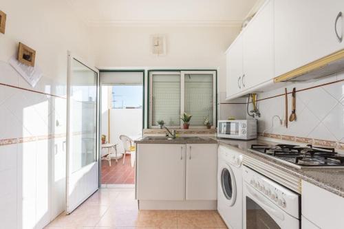 カバナス・デ・タビラにあるHOME4U - Cosy Apartment with Fantastic Terraceのキッチン(白いキャビネット、コンロ付)