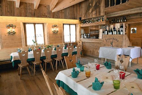 un ristorante con tavoli e sedie in una stanza di Jägerhaus Agriturismo a Cortina dʼAmpezzo