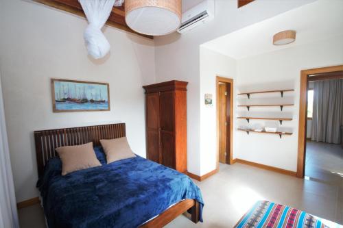 1 dormitorio con 1 cama con manta azul en Casa Ohana, en Barra Grande