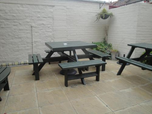 a picnic table and benches on a patio at Beaconsfield Hotel in London