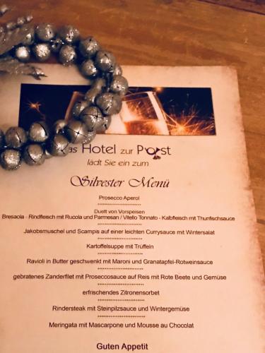 a menu for a restaurant with a necklace on it at Posthotel Sachrang in Sachrang