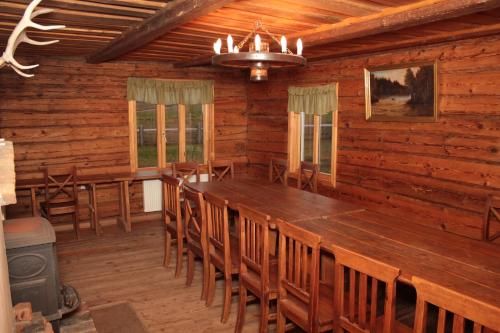 a dining room with a large wooden table and chairs at Sodyba Pasartėlė in Kavoliai