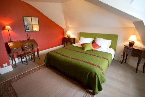 a bedroom with a green bed and a piano at B&B Vassy Etaule in Avallon