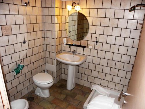 La salle de bains est pourvue d'un lavabo, de toilettes et d'un miroir. dans l'établissement Agriturismo La Colombaia, à Capua