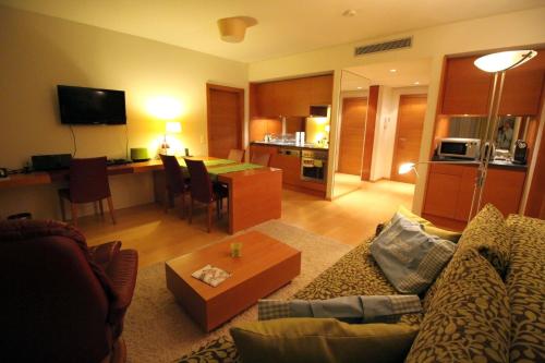 a living room with a couch and a dining room at Golf & Wellness Apartment 34. in Bad Waltersdorf