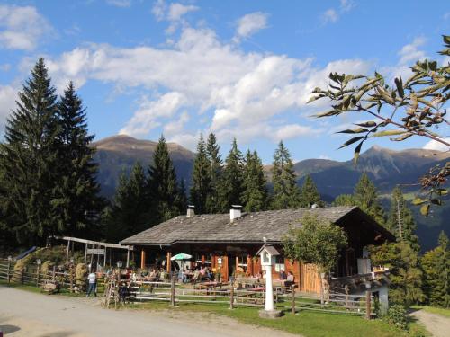 a log cabin with people sitting outside of it at Familienwanderhof Eggeler in Liesing
