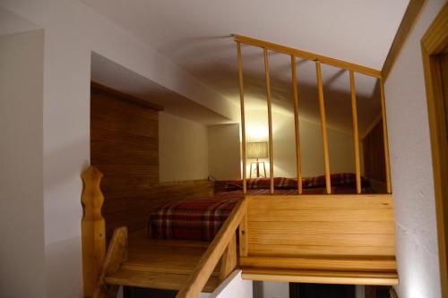 a bedroom with a bed and a wooden staircase at White Attic in Breuil-Cervinia