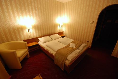 ブダペストにあるHotel Amadeusのベッドと椅子付きのホテルルーム