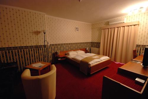 ブダペストにあるHotel Amadeusのベッドとデスクが備わるホテルルームです。