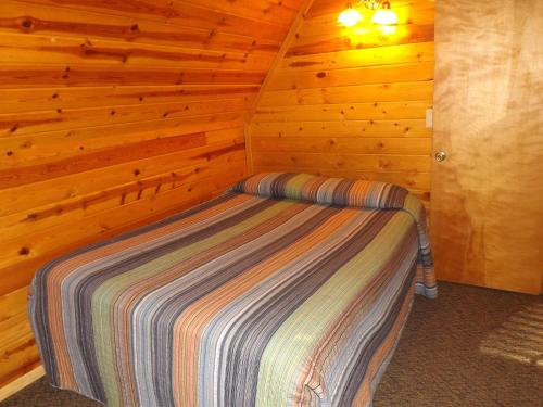 a bedroom with a bed in a wooden cabin at Arizona Mountain Inn & Cabins in Flagstaff