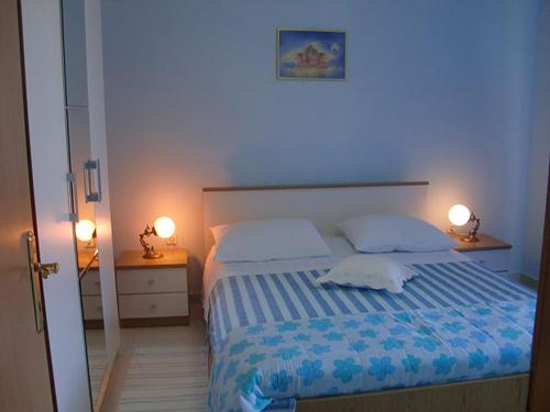 a bedroom with a bed with two lamps on both sides at Apartment Marina in Slatine