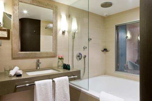 a bathroom with a tub and a sink and a shower at Sofitel Marseille Vieux-Port in Marseille