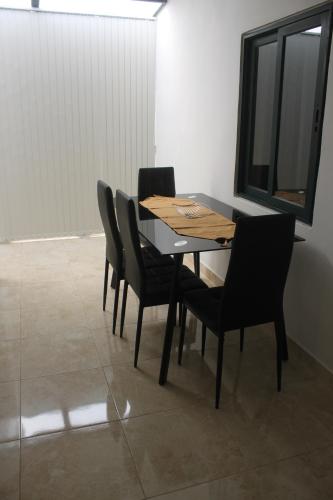 a dining room table with black chairs and a window at St Joseph Penthouse in Victoria