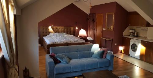 a living room with a blue couch and a bed at Studio Maison 3 Kapana in Plovdiv