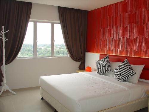 a bedroom with a large bed with a red wall at Duta Hotel & Residence in Kuala Lumpur