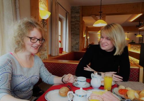 two women sitting at a table eating breakfast at Gasthof Edelbrunn in Ramsau am Dachstein