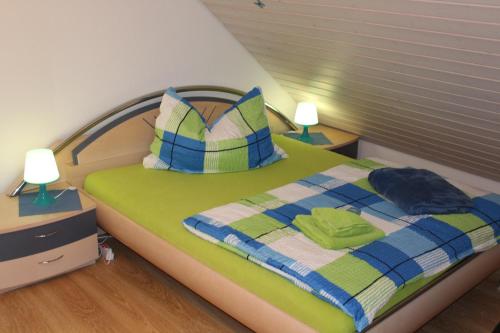a bedroom with a green and blue bed with two lamps at Schlicht & einfach Traumhaft in Unterkulm
