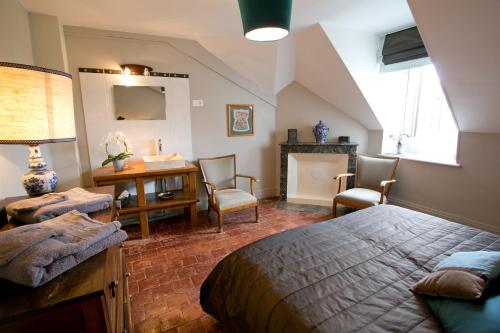 a bedroom with a bed and a desk and a table at B&B Vassy Etaule in Avallon