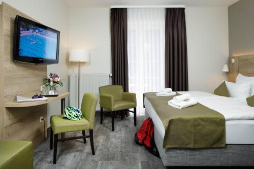 a hotel room with two beds and a television at Am Schloßbrunnen Bad Muskau in Bad Muskau