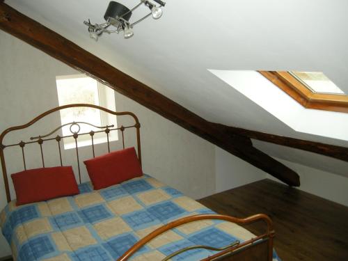 1 dormitorio con 1 cama con 2 almohadas rojas en les Jéhans en Chateauroux-les-Alpes