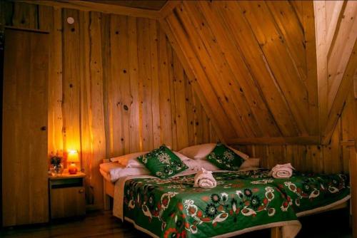 1 dormitorio con 1 cama en una pared de madera en Agrotatry U Stachy, en Bukowina Tatrzańska