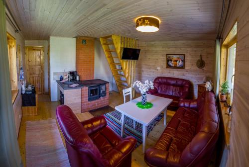 a living room with leather furniture and a table at Holiday Home with Sauna in Kassari