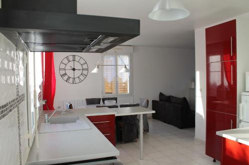 una cocina con fregadero y un reloj en la pared en Le Chouette Logis, en Verneuil-en-Halatte