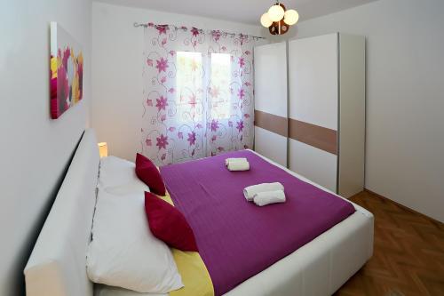 a bedroom with a bed with two towels on it at Apartmani Nena in Ždrelac