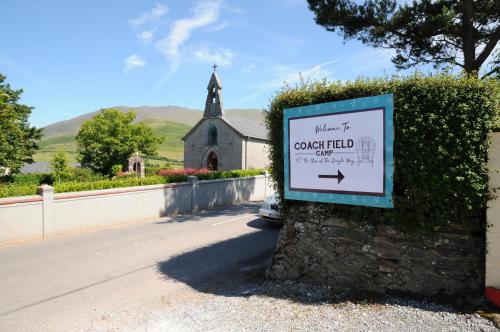 a sign in front of a church with a building at Coach Field Camp in Camp