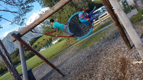 a young boy on a swing at a playground at Apartment Bergverliebt in Mieming