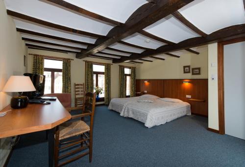 Thulin的住宿－埃姆XIX旅館，一间卧室配有一张床和一张带电脑的书桌