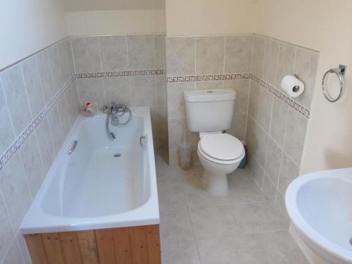 a bathroom with a toilet and a tub and a sink at No 9 in Bognor Regis