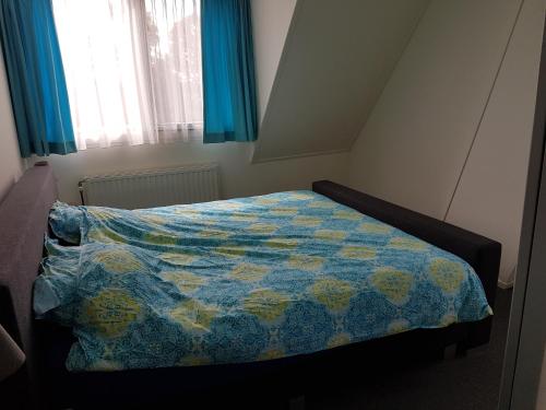 スロースケルケにあるLeeuwendammeのベッドルーム1室(青と黄色のキルトのベッド1台付)