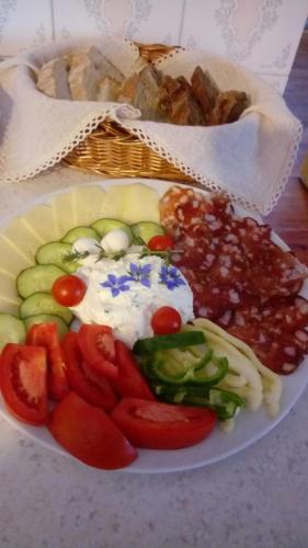 a plate of food with vegetables and a basket of bread at Farm Stay Žagar in Mozirje