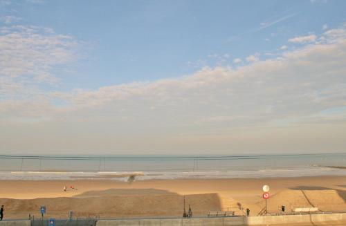 a beach with people on the sand and the water at Appartement met zeezicht max 6 p in Ostend