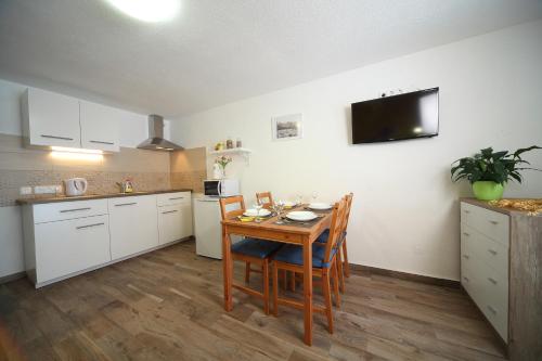 a kitchen with a table and chairs and a tv on the wall at Danijela & Gregor in Rateče