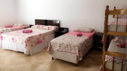 una habitación con 3 camas y una escalera. en Hotel Kika, en São Gabriel