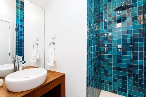a bathroom with a sink and a shower with blue tiles at Chalet Estoril Luxury Apartments in Estoril
