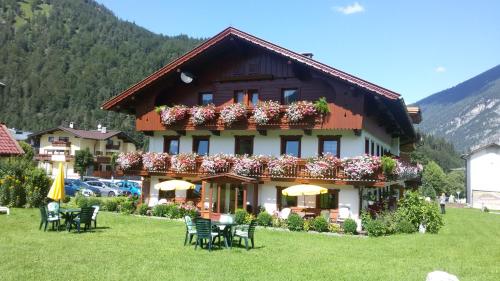 a building with flowers on the front of it at Apartments & Zimmer Urschnerhof in Pertisau