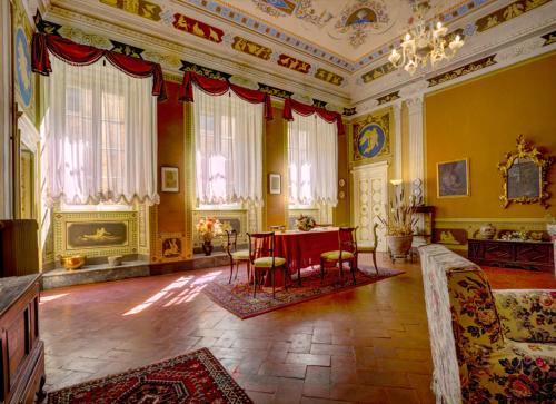 ヴォルテッラにあるResidenza Storica Palazzo Ricciarelliのテーブルと椅子が備わる広い客室です。