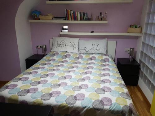 ナポリにあるCasa Nilaのベッドルーム1室(カラフルな掛け布団付きのベッド1台付)