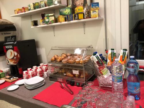 a table with a bunch of donuts and bottles of water at Hotel Villa Enea in Cattolica