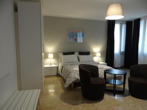 ヴェネツィアにあるPalazzo Boldù - Ca' Colombinaのベッドルーム1室(ベッド1台、椅子2脚、テーブル付)