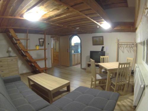 - un salon avec un escalier, une table et des chaises dans l'établissement Ubytování U Vořechovských, à Pec pod Sněžkou