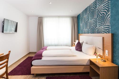 a hotel room with a large bed and a window at Hotel Sarah in Heinsberg